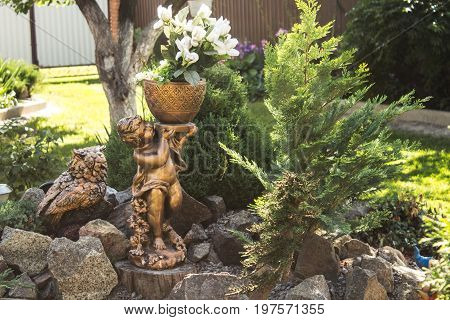a statue of a woman with a flower pot in the garden