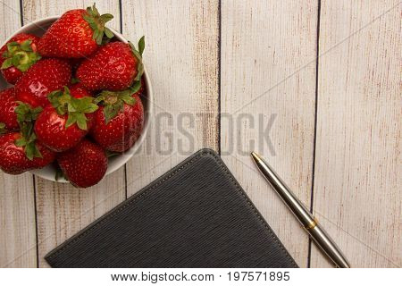 Strawberry tablet and pen summer wooden background