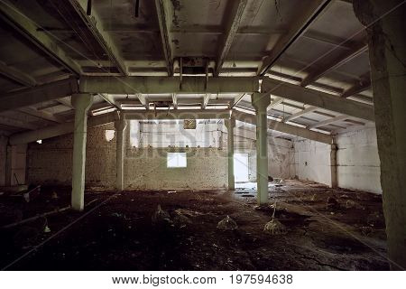 Abandoned industrial warehouse big room, dark and scary, toned