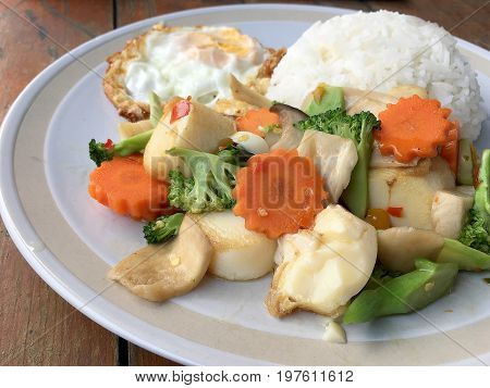 Mixed Fried Vegetable Tofu With Rice And Fried Egg In White Dish On Wooden Background. Vegetarian Fo