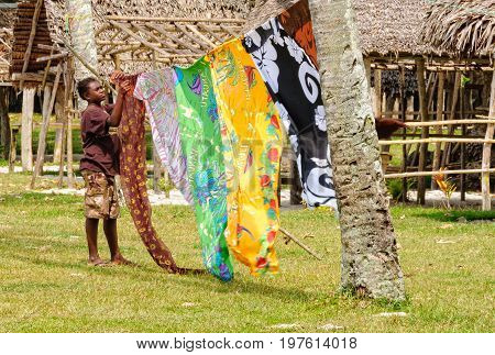 A local vendor with colourful sarongs fluttering in the breeze at Champagne Beach - Espiritu Santo, Vanuatu, 26 September 2012