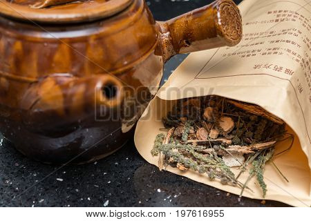 herbal near to an enamel pot the chinese words explains the way to decoct the herbal medicine in detail