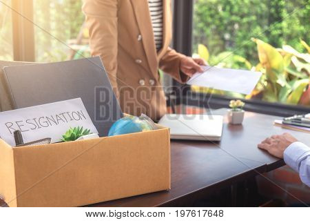 Close up of the hand employer filing final remuneration to resignation employee packing up all his personal belongings and files into a brown cardboard box resign concept.