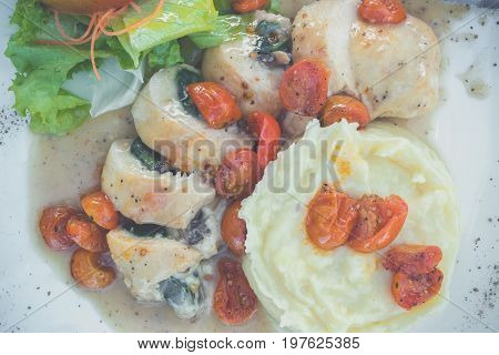 Sliced chicken with mashed potato and tomato cherry in italian sauce. Italian restaurant. delicious dinner.