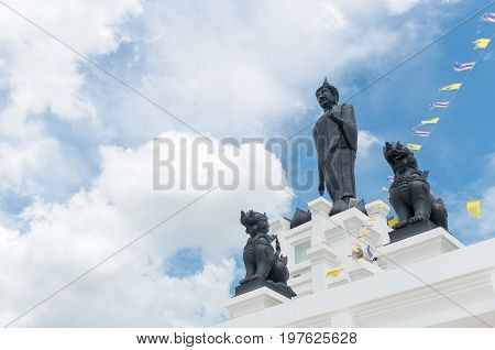 Black Big Buddha statue with white cloudy and blue sky at Kroen Kathin temple Most Famous public temple in Lop Buri province THAILAND