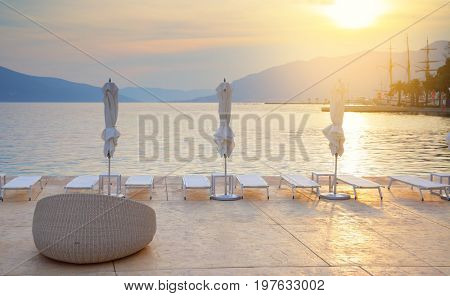 Beach of sea resort with chair and umberllas at sundown