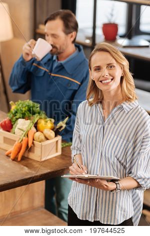 Quick refreshment. Pretty smart charismatic lady singing the papers confirming the delivery while treating the man for his services