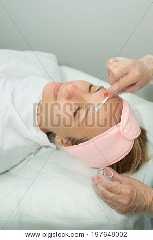 Beautiful young girl on facial cleansing procedure at a cosmetologist