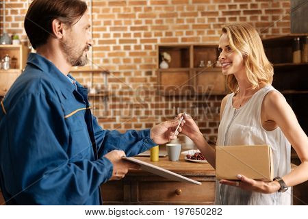 Satisfied with services. Lively gallant capable man asking for womans signature while needing it for confirming the act of receipt