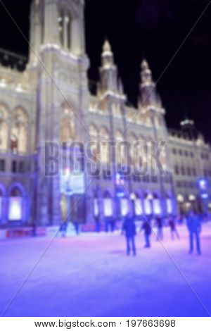abstract blurred: people skate on the ice in the night city Europe