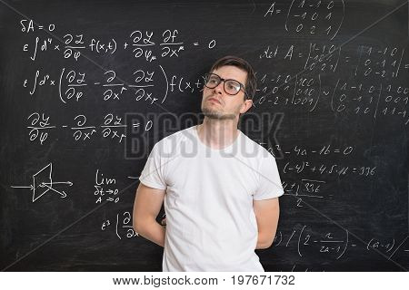 Young Student Is Solving Math Exam. Mathematics Formular On Blac