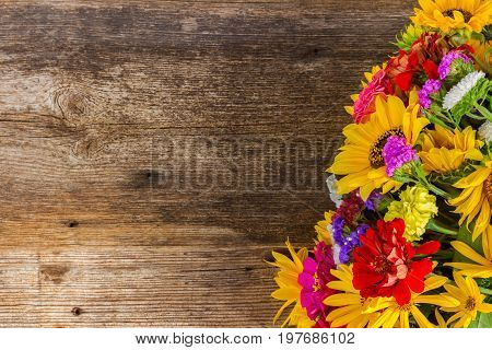 Bright bouquet with fresh fall flowers on wooden textured table with copy space