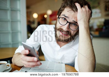 Nervous man with smartphone seeking for job