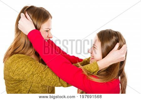 Photo of young sisters fighting on isolated white background