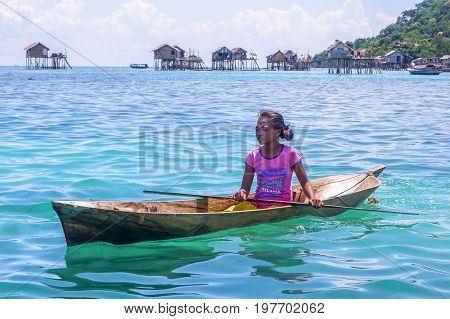 Semporna,Sabah,Malaysia-Apr 23,2017:Sea Gypsy kid girl rowing an unique handmade boat surrounded by beautiful clear water of the Bodgaya island,Semporna,Sabah,Malaysia.