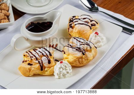 Eclairs with the dark hot chocolate and beze