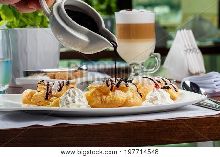 Eclairs with the dark hot chocolate and beze