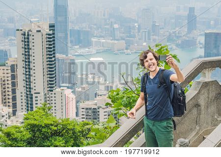 Hong Kong Victoria Peak Man Taking Selfie Stick Picture Photo With Smartphone Enjoying View Over Vic