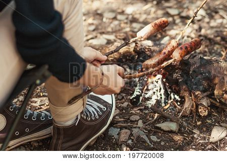 Camping in the wild - Grilled sausages above the campfire.