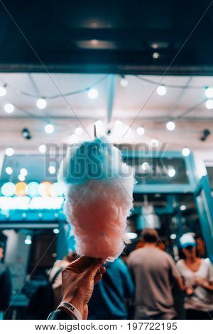hand holding cotton candy on the night street