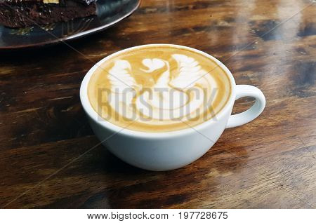 Hot coffee with foam milk art. Black cup of coffee. Hot coffee in afternoon break. Coffee cup. coffee mocha on the wood desk. Coffee break.(selective focus vintage effect)