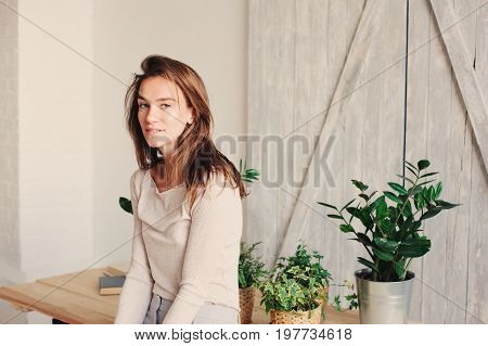 beautiful young feminine woman relaxing at home in lazy weekend morning with cup of coffee wearing casual fashion clothes