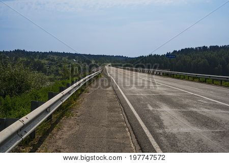 Road shot at the entrance to the bridge over the river Vyatka in summer