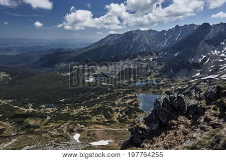 Peak rock snow meadow forest peak spruce tree shrub sky cloud rock plant landscape back lake water mountains Tatra Mountains Poland Europe