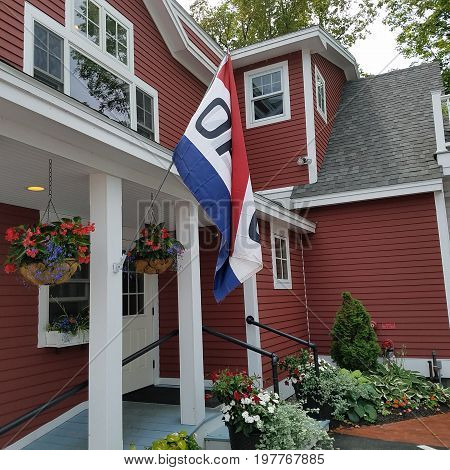 Red house, open flag, flower pots in the summertime