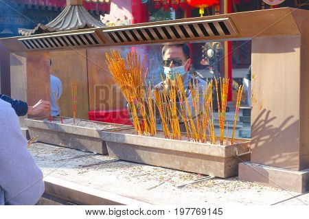 HONG KONG, CHINA - JANUARY 22, 2017: Unidentified people burning incenses inside of Wong Tai Sin Buddhist Temple to pray, in Hong Kong, China.