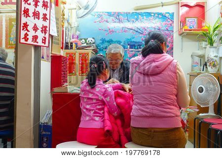 HONG KONG, CHINA - JANUARY 22, 2017: Unidentified people talking in a office inside of Wong Tai Sin Buddhist Temple to pray, in Hong Kong, China.