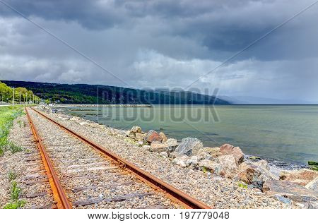 Railroad With Stormy Sky And Saint Lawrence River In Saint-irenee, Quebec, Canada In Charlevoix Regi