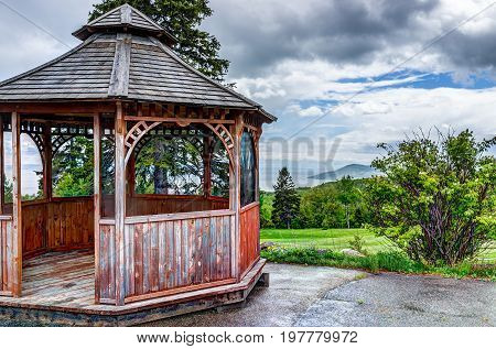 Closeup Of Brown Empty Gazebo In Summer Landscape Overlooking Coast