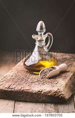 flax seeds and linseed oil in a glass jug on a wooden table, healthy diet with omega 3 fatty acids