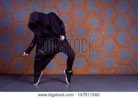 Young dancer standing on his tiptoes near the wall. Urban style
