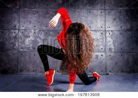 Girl dancing in front of the urban wall.
