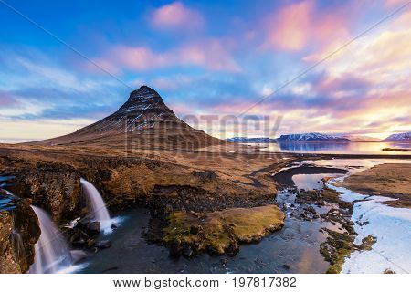 Spring Sunrise Over The Famous Kirkjufellsfoss Waterfall With Kirkjufell Mountain In The Background