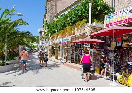 PETROVAC MONTENEGRO - SEPTEMBER 19 2015: Unidentified people walk along souvenir shops on promenade in popular resort town of Petrovac Montenegro