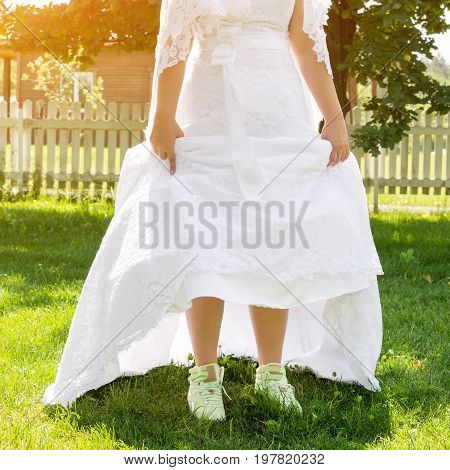 Funny beautiful bride wearing green running shoes. Runaway Bride, close up