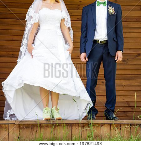 Funny beautiful wedding couple. Bride wearing green running shoes. Runaway Bride, close up