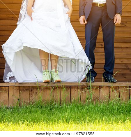 Funny beautiful wedding couple. Bride wearing green running shoes. Runaway Bride, close up
