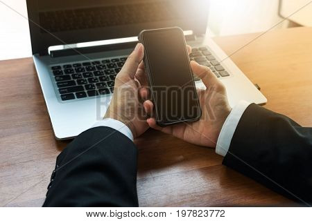 Side view shot of a man's hands using smart phone in interior rear view of business man hands busy using cell phone