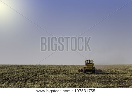 Farmer in tractor preparing land with seedbed cultivator