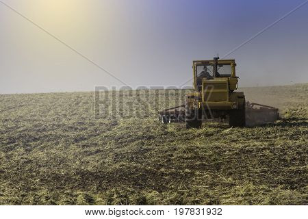 Farmer in tractor preparing land with seedbed cultivator