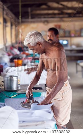COCHIN, INDIA - JANUARY 21, 2016: Indian man working hard on Dhobi Ghat in Fort Cochin, Kerala