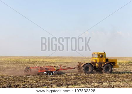 Farmer in tractor preparing land with seedbed cultivator