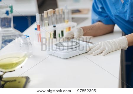 Precise dose. Close up of medical powder being weighted on electronic scales by a skillful smart scientist