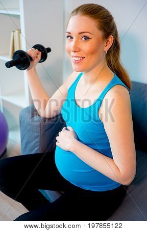 Pregnant woman doing pre-natal exercises at home