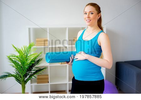 Pregnant woman doing pre-natal exercises at home