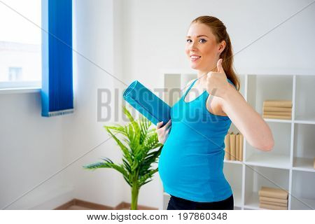 Pregnant woman doing pre-natal exercises at home